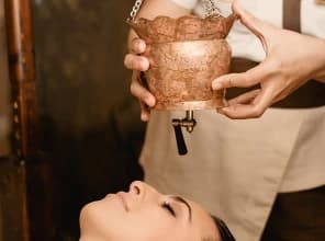 Therapist performing an Ayurvedic massage with traditional oils in Malta