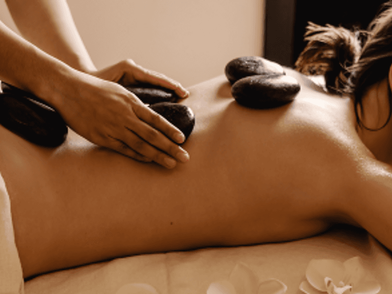 American hot stone massage in Malta — heated basalt stones for deep muscle relief at Carisma Spa