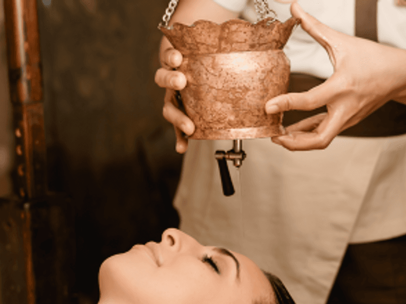 Therapist performing an Ayurvedic massage with traditional oils in Malta